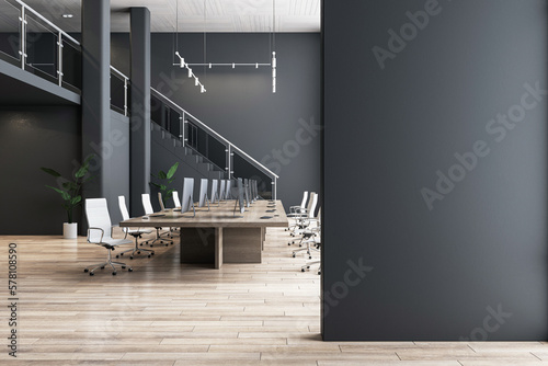 Fotomurale Blank black partition with place for advertising poster or logo in modern interior design spacious office hall with conference table, wooden floor and dark wall background