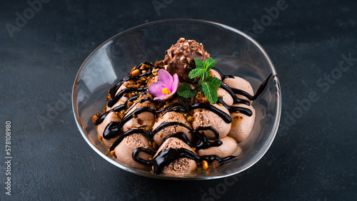 Tiramisu cake dessert with chocolate candy, nuts, mint and sweet sauce.