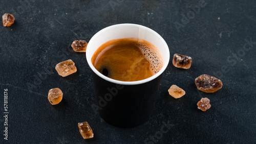 Cup of hot espresso coffee, black coffee in paper cup on dark background.