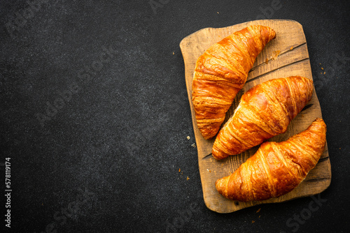 Croissant at black background. French pastry, bakery, fresh dessrt. Top view.
