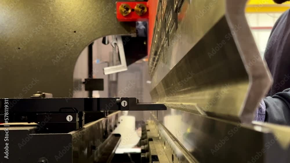 video of side view of a metal bending machine of a worker working and ...