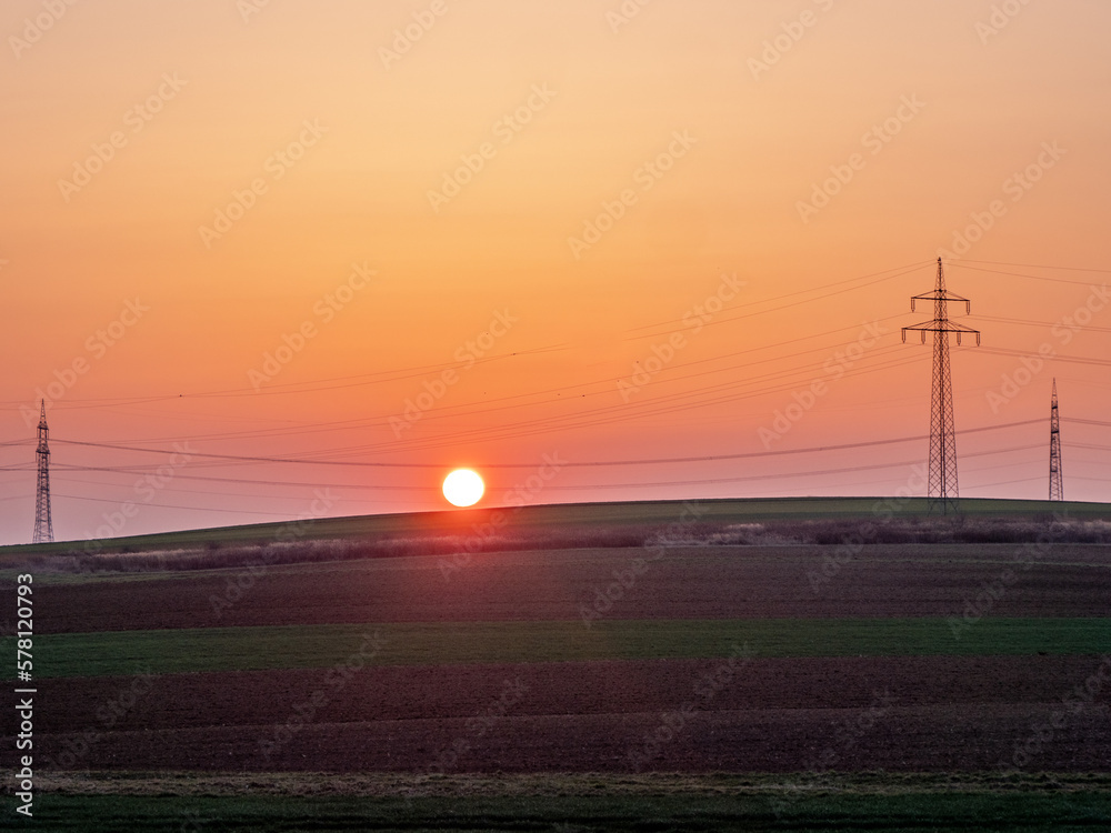 Obraz premium Strommasten in der Ferne imi Sonnenuntergang