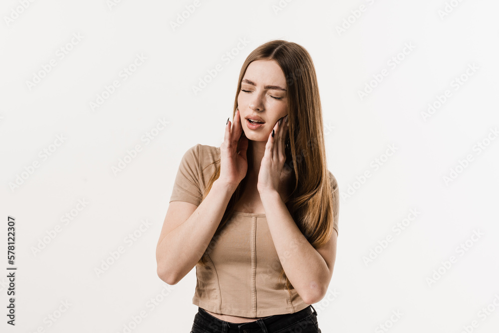Girl is touching cheek and feeling toothache pain and discomfort of tooth. Girl with tooth decay, infection or injury to the tooth or gums on white background. Girl is touching cheek and feeling toothache pain and discomfort of tooth. Girl with tooth decay, infection or injury to the tooth or gums on white background.