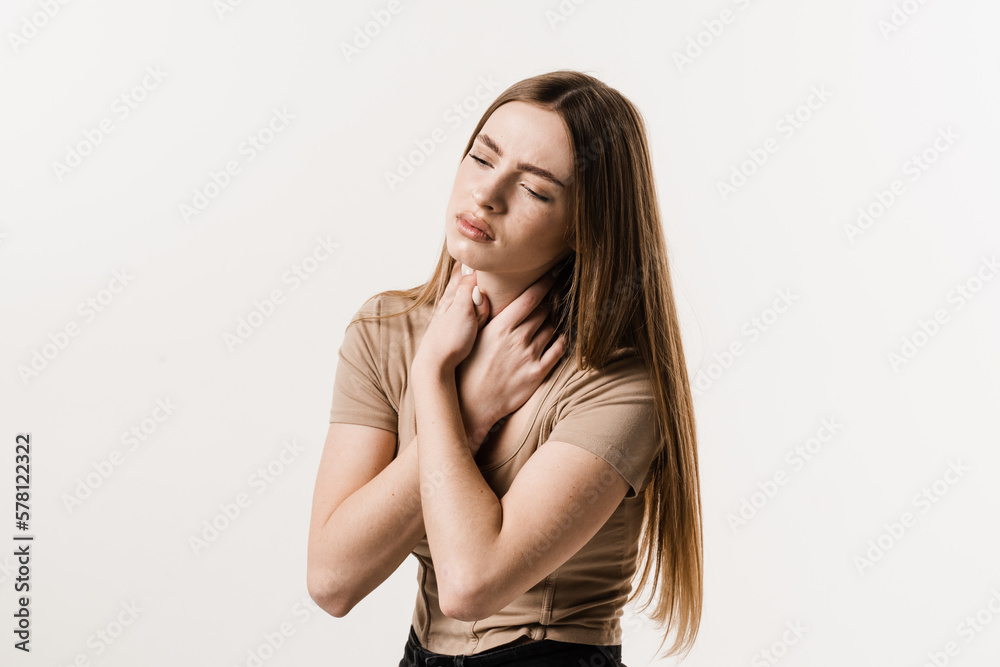 Laryngitis first symptoms throat ache. Seasonal illness medecine. Sick girl touches throat with pain on white background.