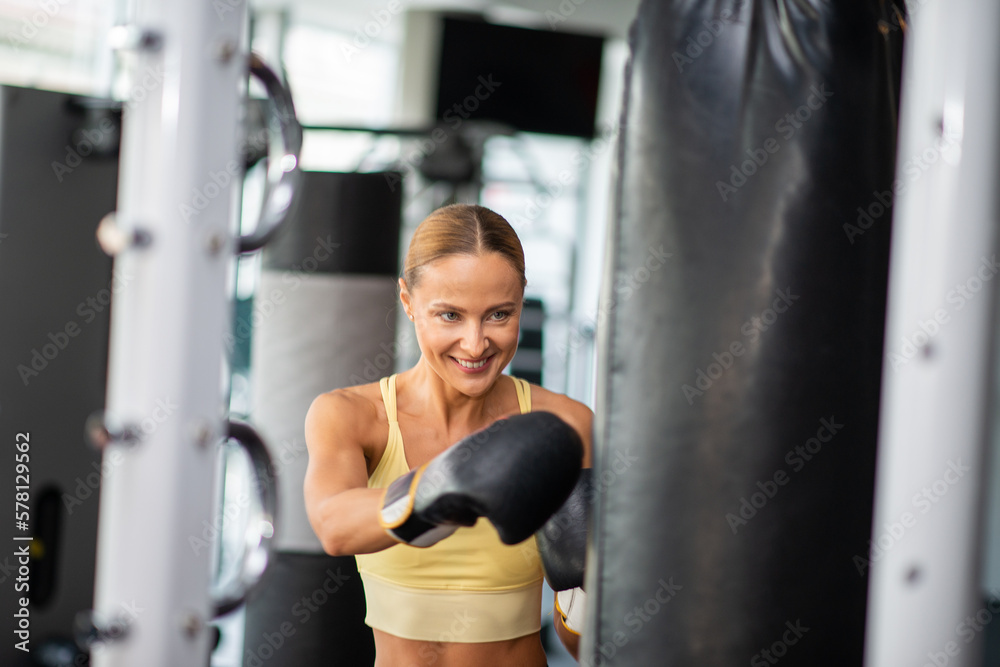 Woman training on the punching bag in a gym
