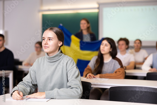 Young female student attentively listening to a lecture in a classroom