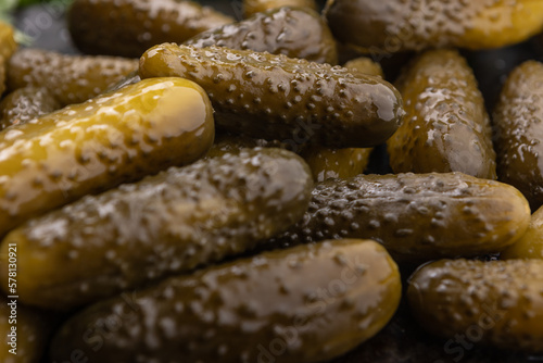 Ogórki kiszone, stos ogórków na ciemnym rustykalnym tle. Plakat zdrowa dieta warzywna.