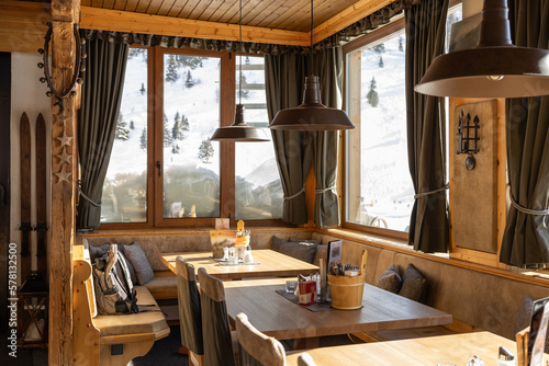 Illuminated by bright morning sunlight, the hall of the restaurant with panoramic windows and snow on the windowsills