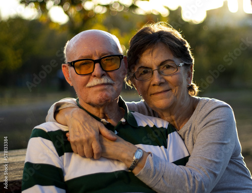 Konstfotografi SEÑOR Y SEÑORA MAYORES ABRAZADOS EN UN PARQUE AL ATARDECER