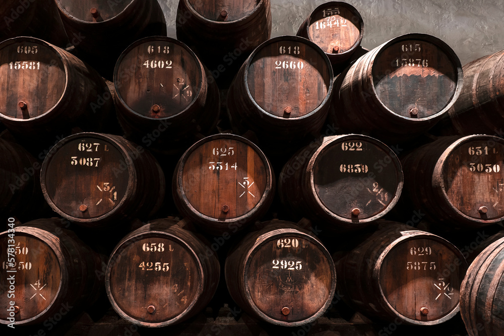 Wine oak barrels in a wine cellar stacked in rows Wine oak barrels in a wine cellar stacked in rows