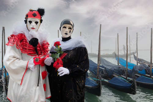 VENICE, Italy - February 17th 2023 Pierrots masks boy and girl at the Venice Carnival with a lagoon background