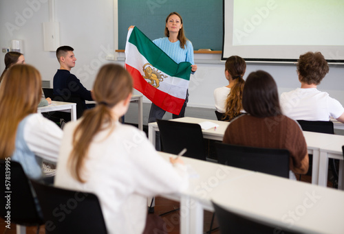 Young female professor shows students flag of Iran before revolution Fototapet