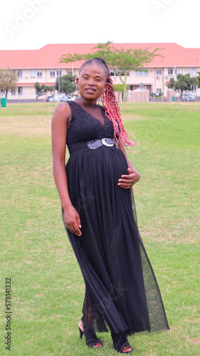 beautiful black pregnant woman smiling  in a fashion dress