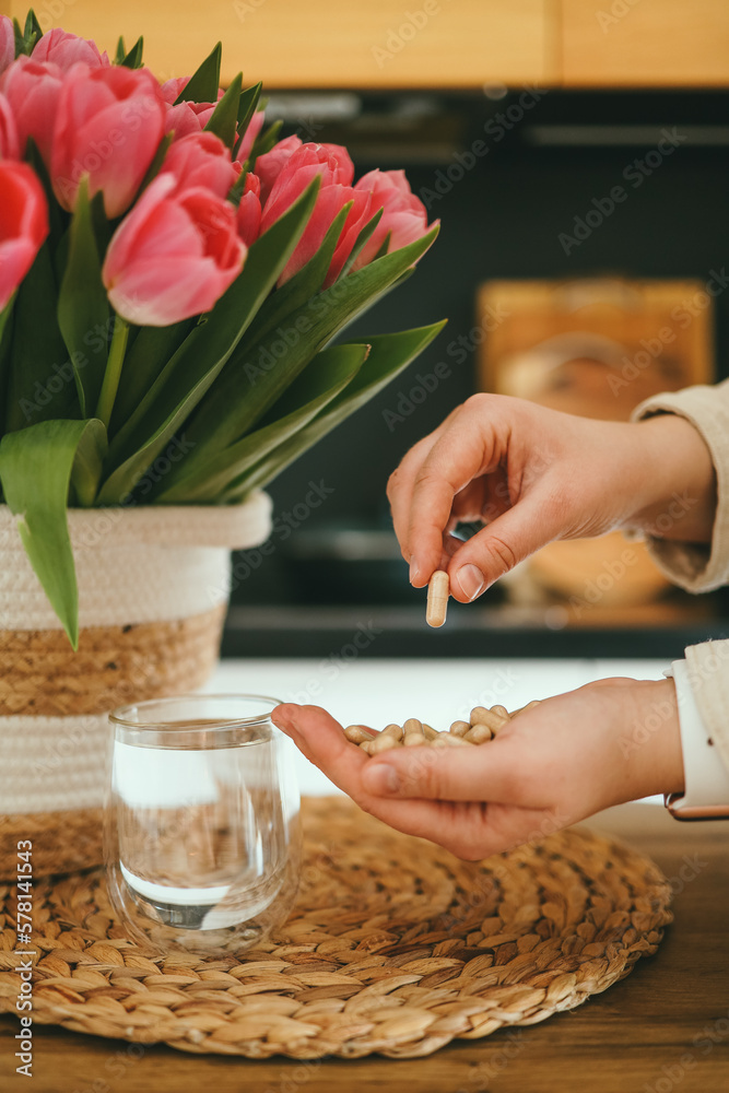 Hands holding vitamins and a glass of water, health care and medicine Hands holding vitamins and a glass of water, health care and medicine