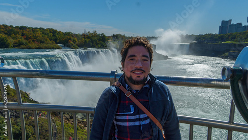 Joven adulto hispano visitando las cataratas del Niagara en Nueva York 
