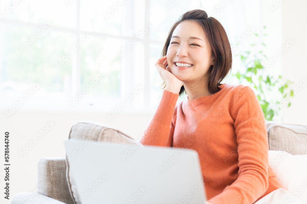 部屋でラップトップコンピューターを見る女性 部屋でラップトップコンピューターを見る女性