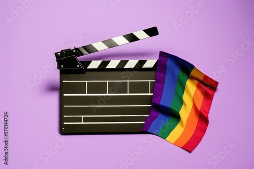 Rainbow flag and black clapperboard on purple background. LGBT CONCEPT. AI generated, human enhanced photo