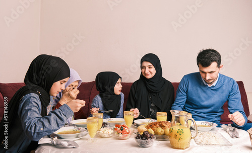 Canvas Print Happy Muslim family having iftar dinner during Ramadan dining table at home