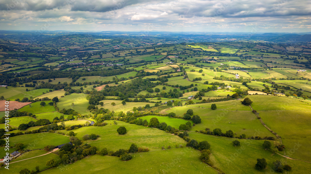 Aerial view of rural farmland and fields in a hilly area (South Wales)