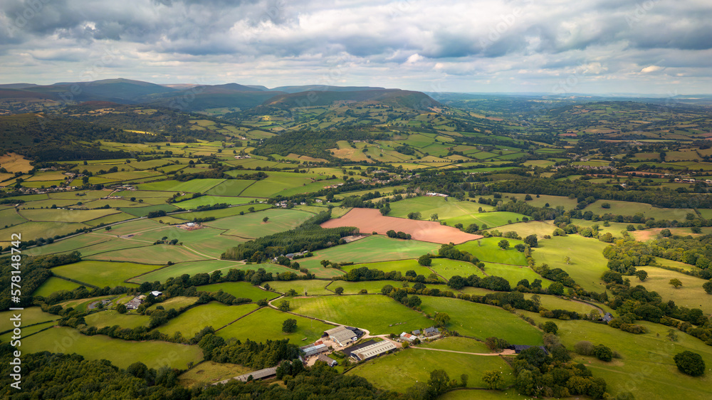 Aerial view of rural farmland and fields in a hilly area (South Wales)