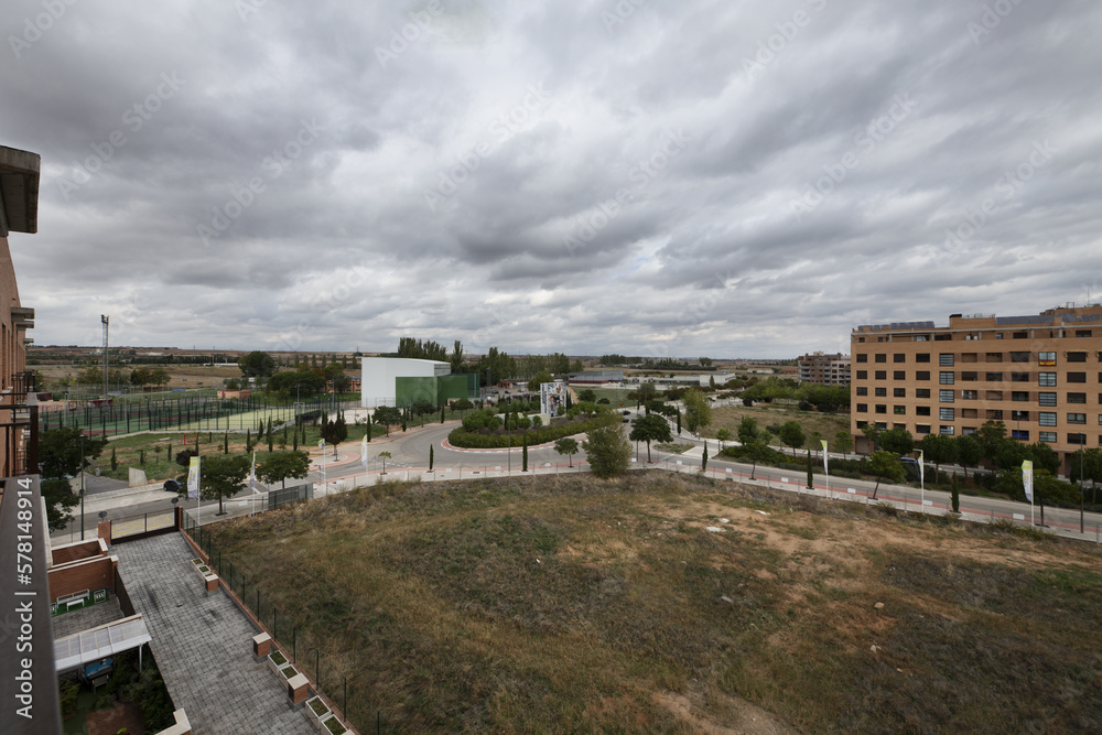 Panoramic views of a residential development with vacant lots on a rain cloud laden winter day