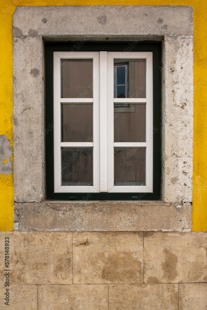 Wooden exterior window of an old house with a stone facade