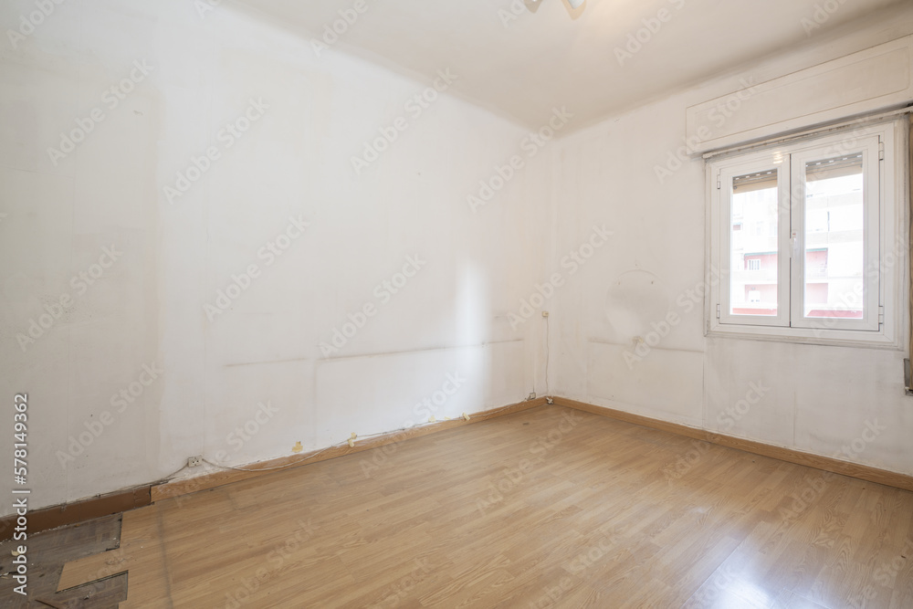 Obraz premium Empty room with poorly installed oak flooring white aluminum window and dirty white walls