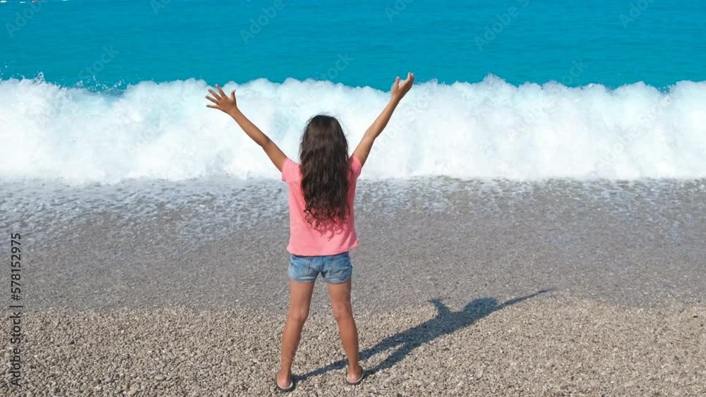 Joyful little traveler on pebbles bay. An emotional child stay on the ...