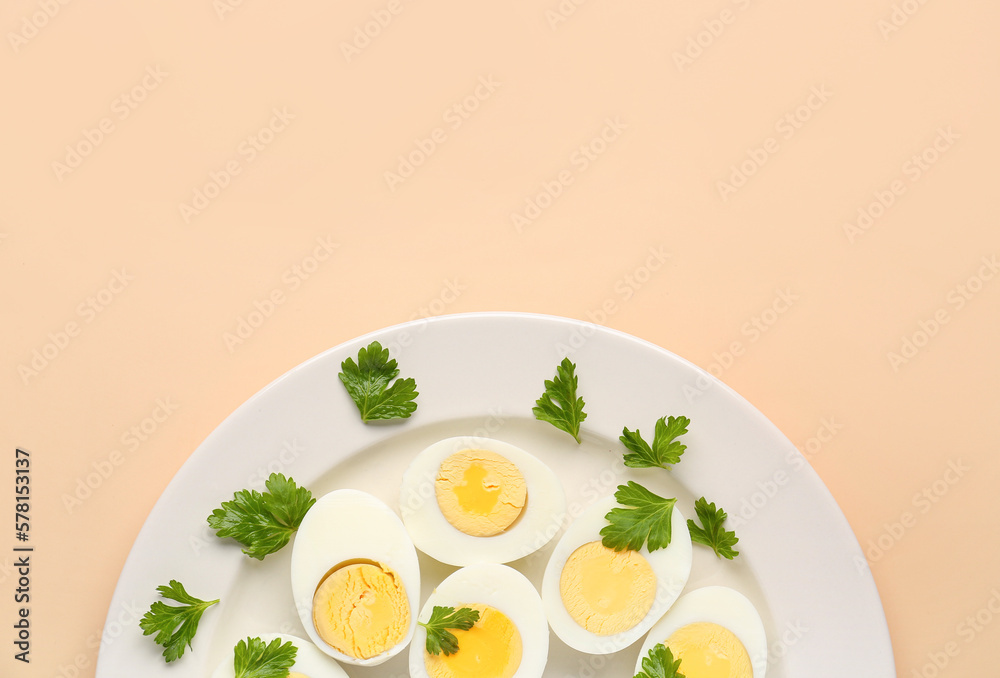 Plate with halves of delicious boiled eggs and parsley on beige background Plate with halves of delicious boiled eggs and parsley on beige background