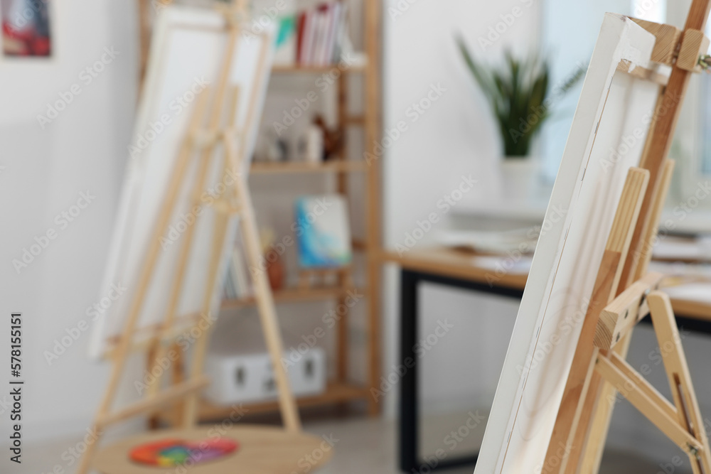 Wooden easel with canvas in artist's studio, space for text. Creative hobby Wooden easel with canvas in artist's studio, space for text. Creative hobby