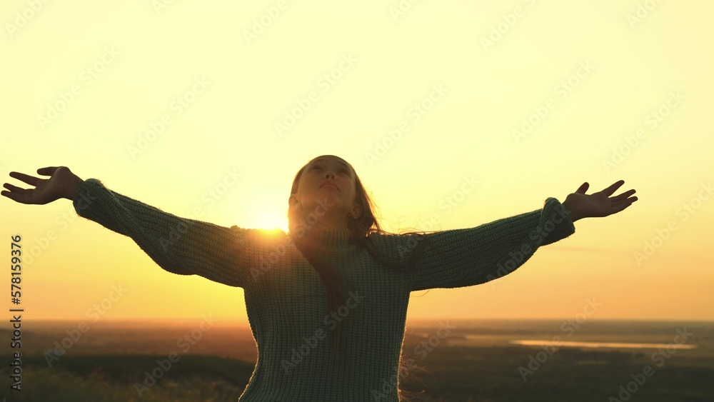 young girl prays looking up sky with her hands up. offer forgiveness, help, confession. man dream.religious girl at sunset. women faith. travel millennial outdoors. girl hair wind rays sun. love life.