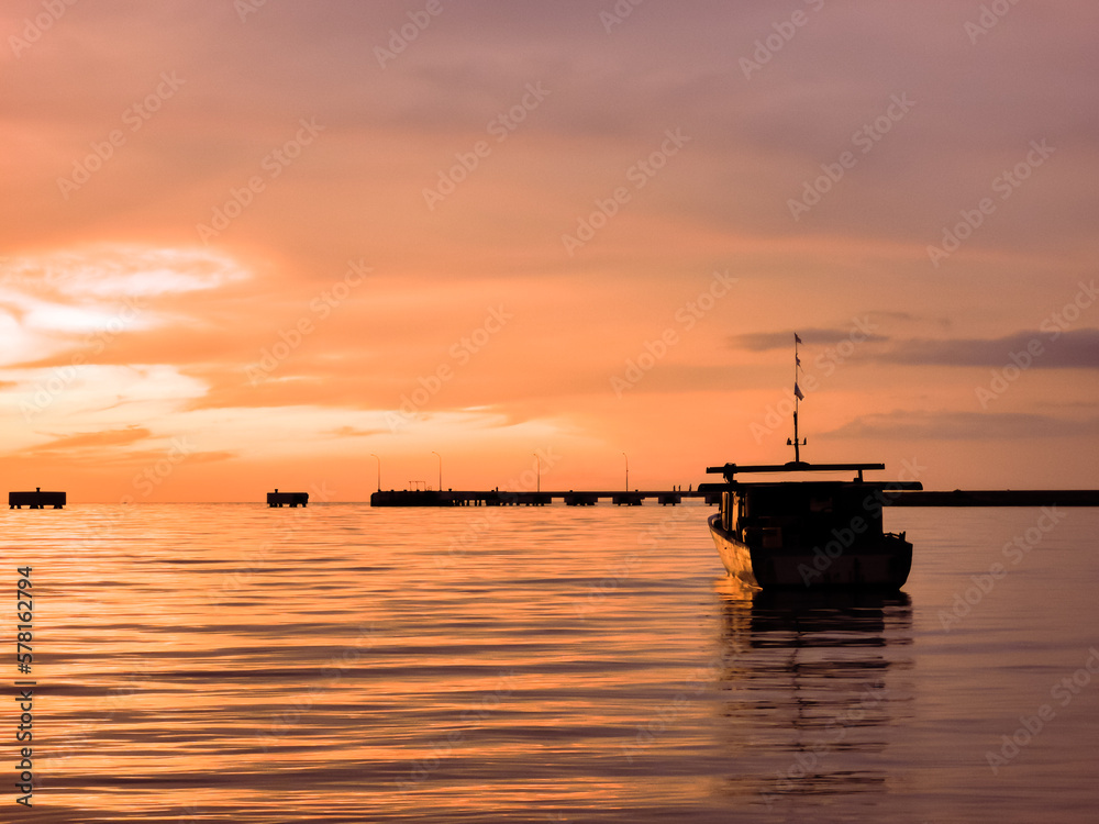 Oudoor scenery during sunset with fisherman's boat in a sea.