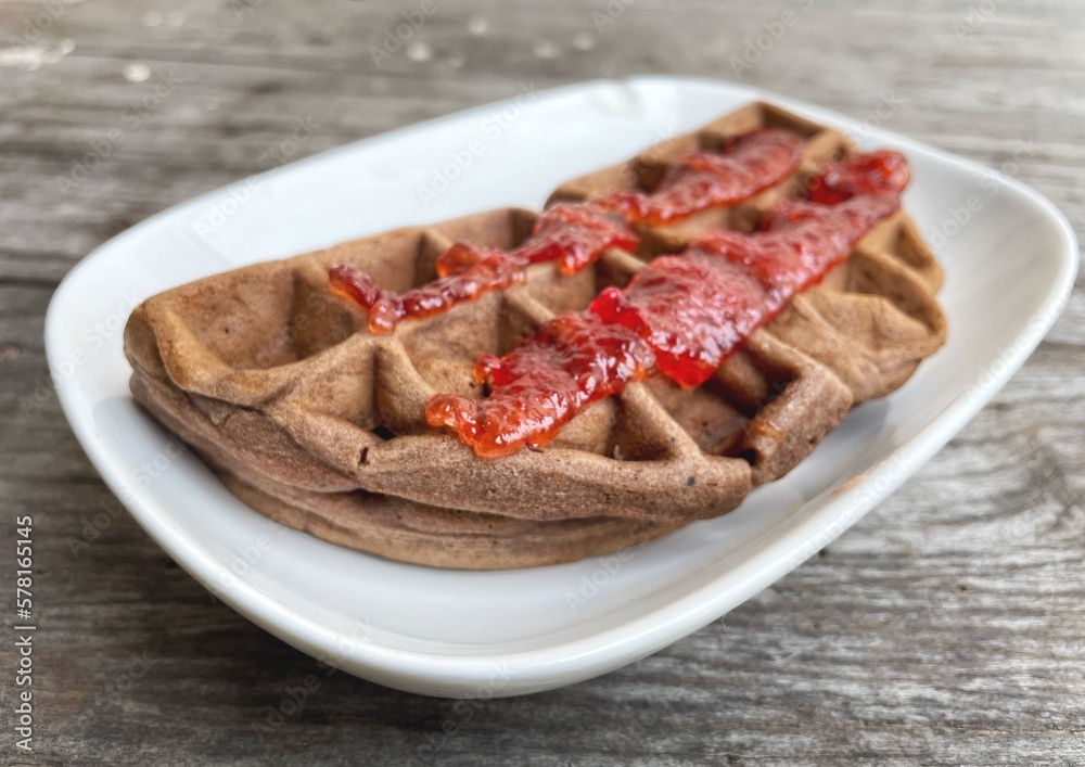 Breakfast of waffle chocolate with strawberry jam and orange juice