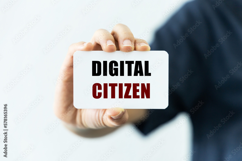 Digital citizen text on blank business card being held by a woman's hand with blurred background. Business concept about digital citizen. Digital citizen text on blank business card being held by a woman's hand with blurred background. Business concept about digital citizen.