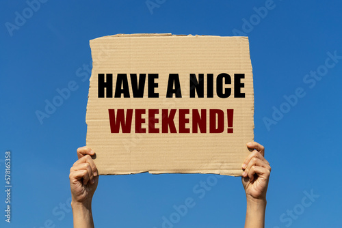 Fotografie Have a nice weeked text on box paper held by 2 hands with isolated blue sky background