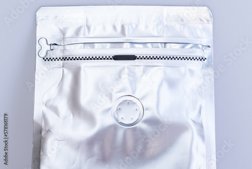 A zip lock coffee bag with degassing valve. A valve allows carbon dioxide to escape without letting oxygen or moisture in. photo