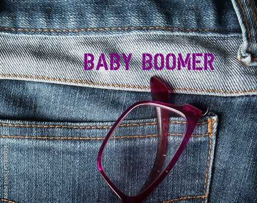 Reading glasses on jeans pocket with text BABY BOOMER , shortend from Baby boomers - demographic generation born following World War II 1946-1964, now mostly in retirement age