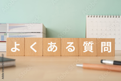 よくある質問と書かれたブロックが置かれたデスク

