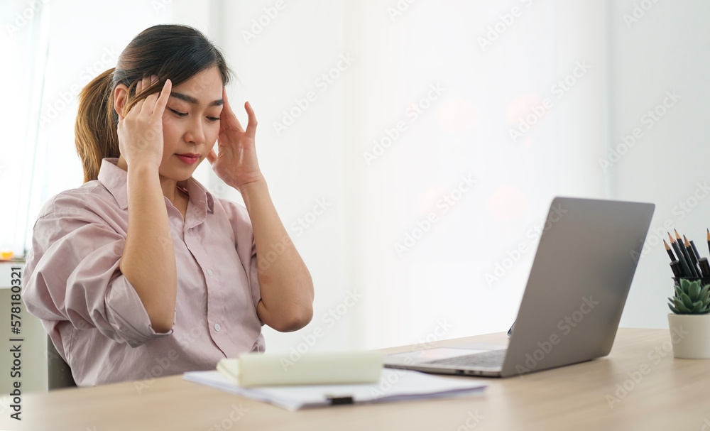 Stressed young businesswoman sitting at her office desk. Stressed young businesswoman sitting at her office desk.