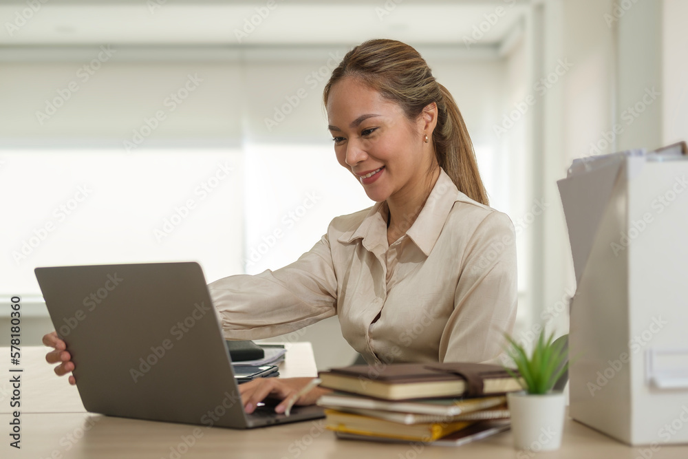 Asian female office worker using laptop computer at comfortable workplace. Asian female office worker using laptop computer at comfortable workplace.