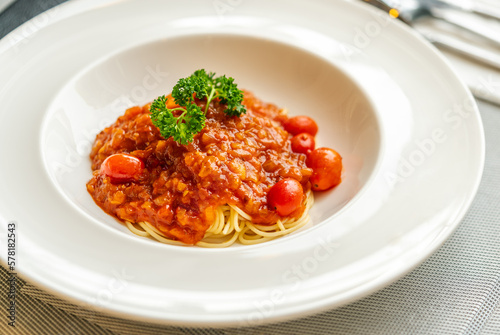 Spaghetti with tomato sauce and minced pork. Spaghetti with tomato sauce in white beautiful dish, natural light from window.