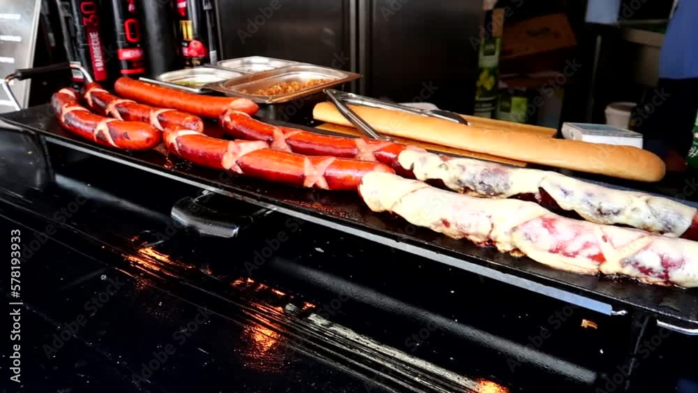 Slow motion panning shot of hot dogs being cooked at a street vendor in London Slow motion panning shot of hot dogs being cooked at a street vendor in London