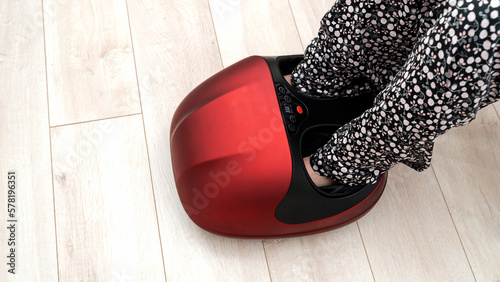 a girl does a foot massage on an electric foot massager