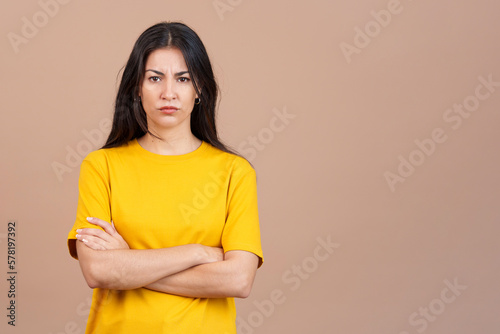 Hispanic woman crossing the arms with an angry expression