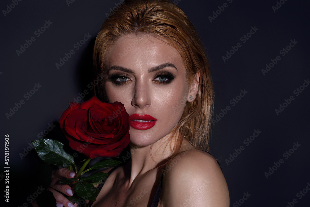 Studio beauty portrait of young beautiful sexy woman with red rose flower.