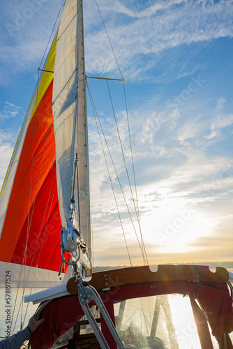 Traveling on a yacht on the ocean, a multi-colored sailboat. Sunset