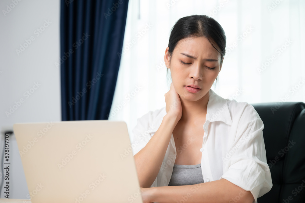 Office syndrome concept. Young asian woman feeling pain in neck and shoulder after working on computer laptop for a long time. She stretches to relax her muscles Office syndrome concept. Young asian woman feeling pain in neck and shoulder after working on computer laptop for a long time. She stretches to relax her muscles
