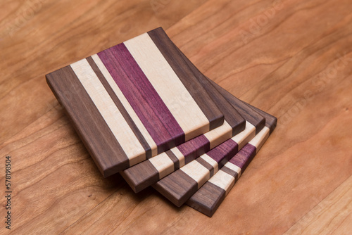 Set of four hardwood coasters with different layers of maple, walnut, purple heart and cherry