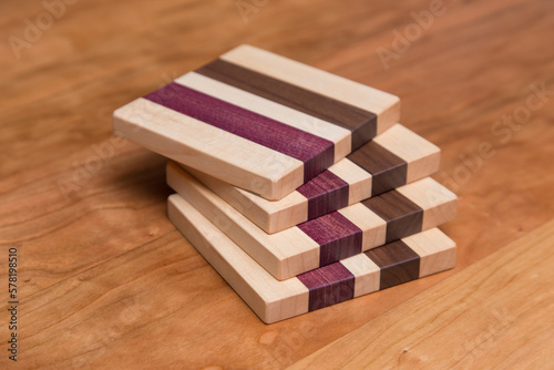 Set of four hardwood coasters with different layers of maple, walnut and purple heart wood
