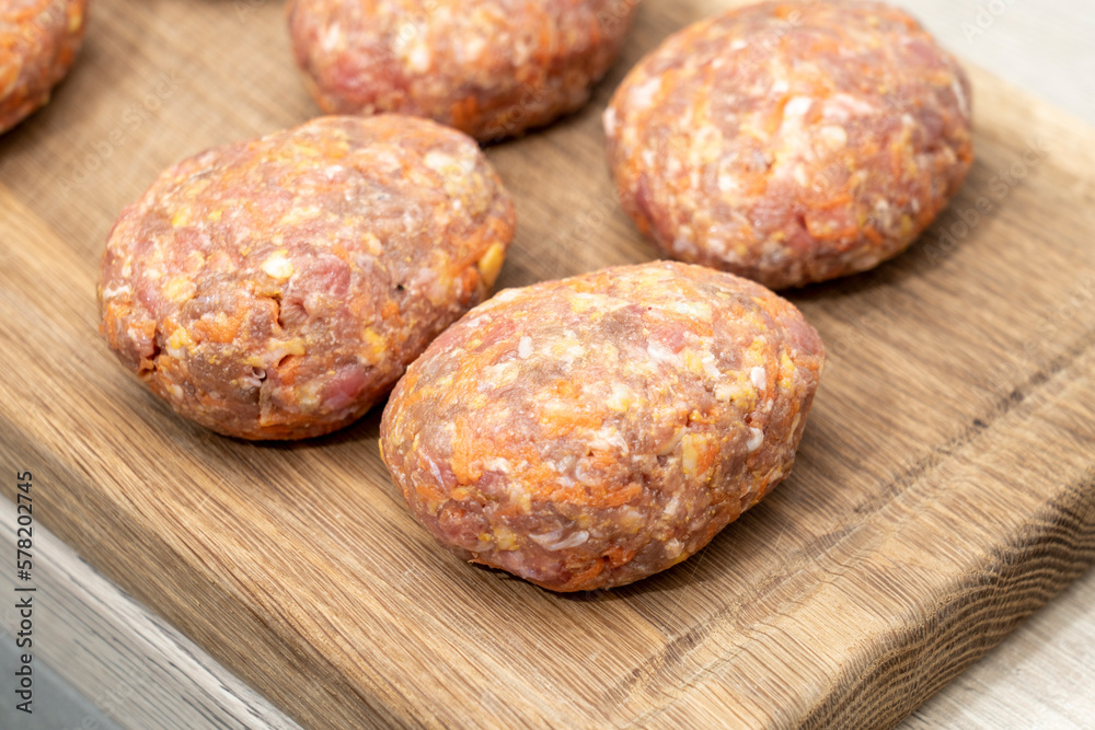 raw homemade meatballs on a massive board made of natural wood raw homemade meatballs on a massive board made of natural wood